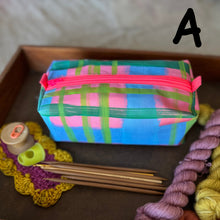 Load image into Gallery viewer, Colorful plaid pouch with pink zipper on a wooden surface with knitting supplies.