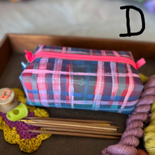 Load image into Gallery viewer, Plaid pouch with pink zipper on a wooden surface with yarn and knitting needles.