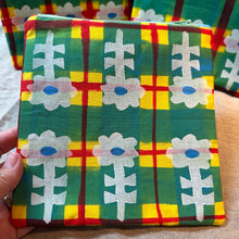 Load image into Gallery viewer, Colorful fabric with a pattern of white flowers on a green background, held by a hand.
