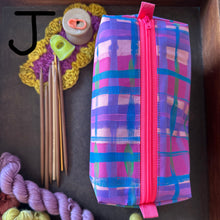 Load image into Gallery viewer, Colorful plaid zippered pouch with knitting needles and yarn on a dark surface
